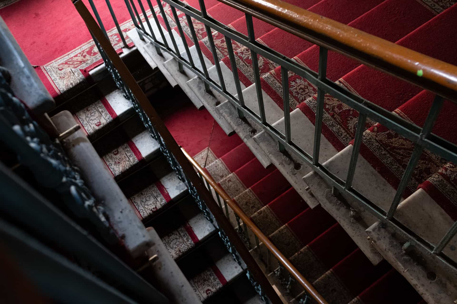 A carpeted staircase seen from the top landing