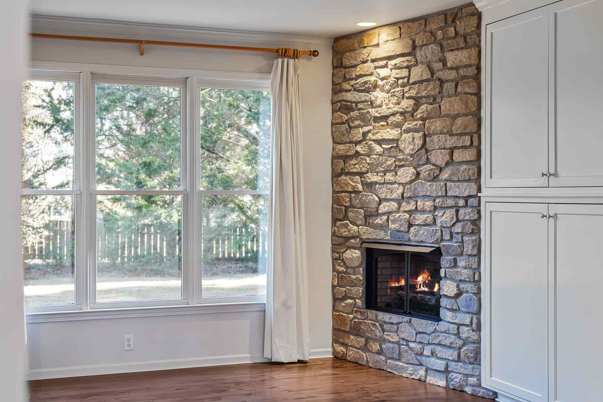A raised stone hearth in front of a fireplace