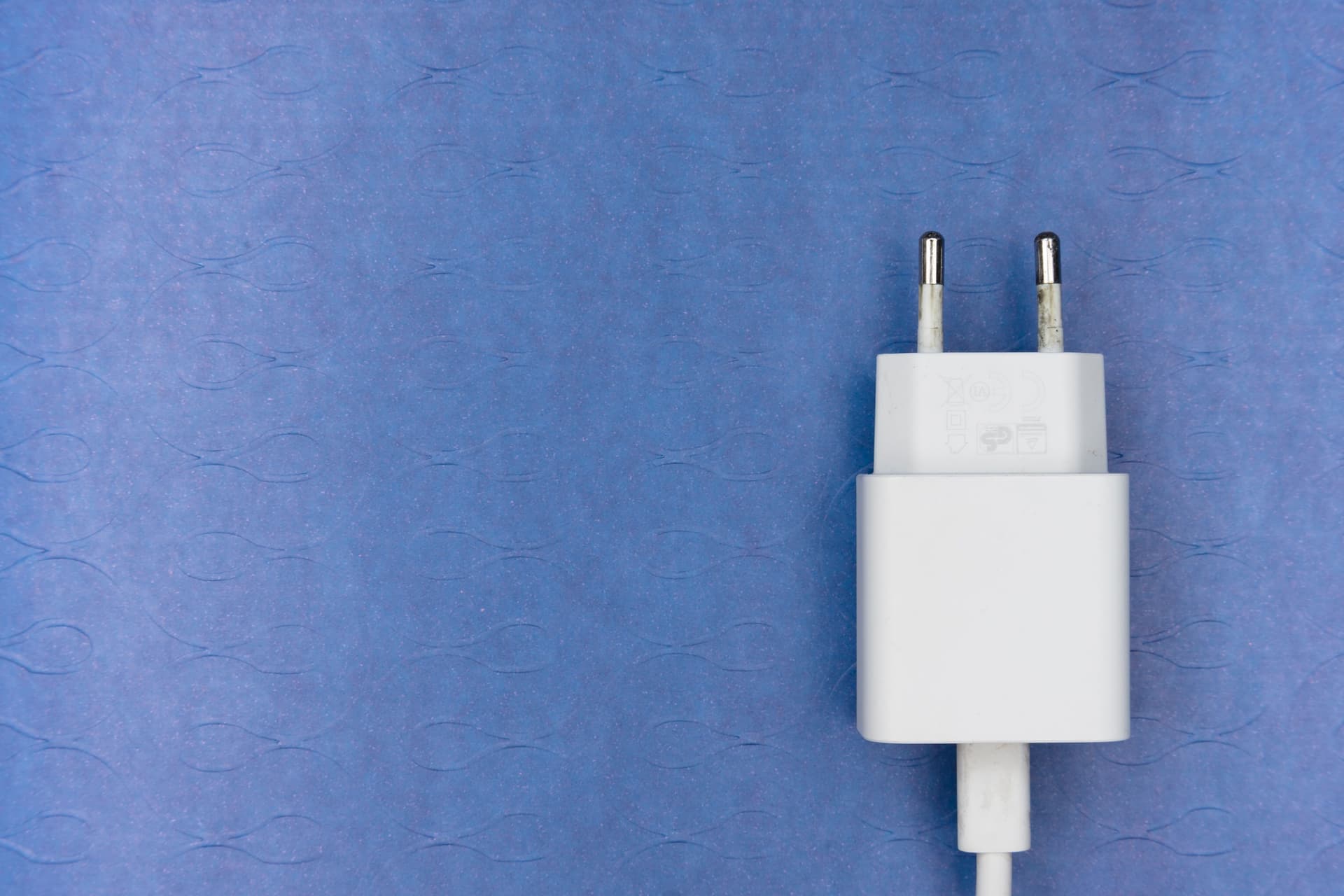 A charger plugged into a wall outlet near the floor