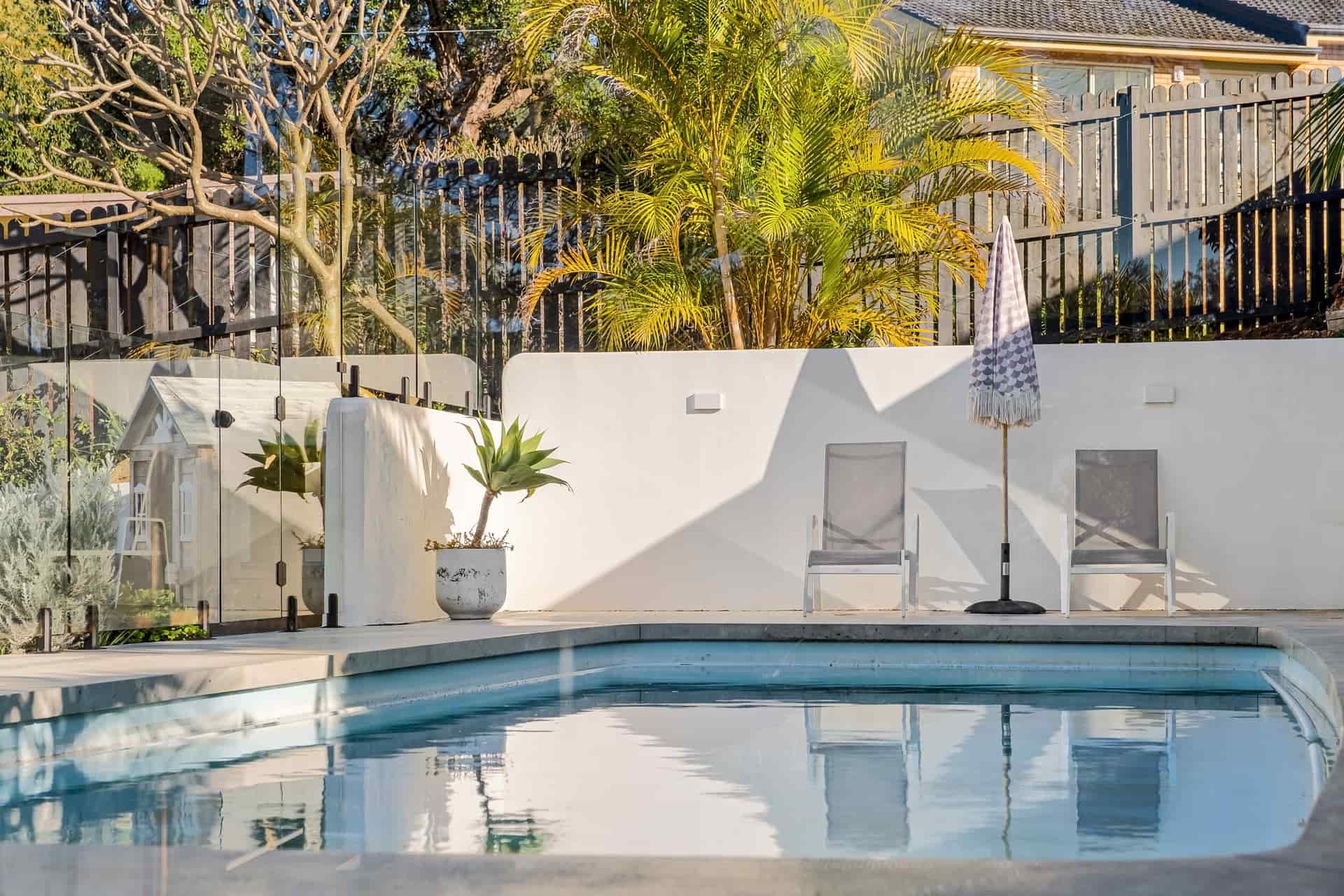 A mesh fence around a backyard swimming pool